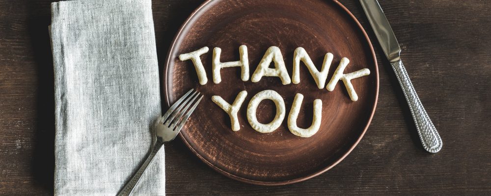 top view of thank you lettering made from cookie dough on wooden plate top view of thank you lettering made from cookie dough on wooden plate